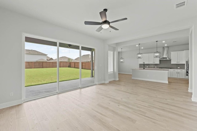 17109 Howdy Way, Manor, TX 78653 - unfurnished living room with a ceiling fan, light wood-style flooring, and baseboards