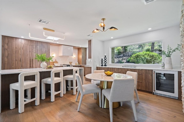 3403 Cascadera Dr, Austin, TX 78731 - dining room featuring wine cooler, a chandelier, light wood finished floors, and recessed lighting