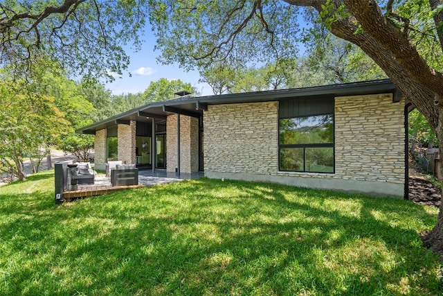 3403 Cascadera Dr, Austin, TX 78731 - rear view of house featuring stone siding, a yard, outdoor lounge area, and a patio area