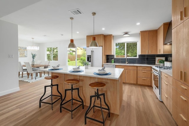 3812 Tarragona Ln, Austin, TX 78727 - kitchen with high quality fridge, gas range gas stove, light wood finished floors, a breakfast bar area, and recessed lighting