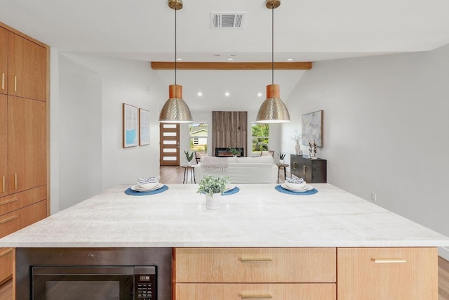 3812 Tarragona Ln, Austin, TX 78727 - kitchen with black microwave, a kitchen island, hanging light fixtures, open floor plan, and recessed lighting