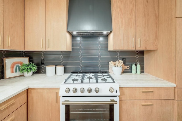 3812 Tarragona Ln, Austin, TX 78727 - kitchen featuring white gas stove, wall chimney exhaust hood, decorative backsplash, and light countertops