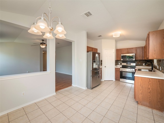 604 Creston St, Hutto, TX 78634 - kitchen featuring stainless steel appliances, vaulted ceiling, a sink, light countertops, and light tile patterned floors