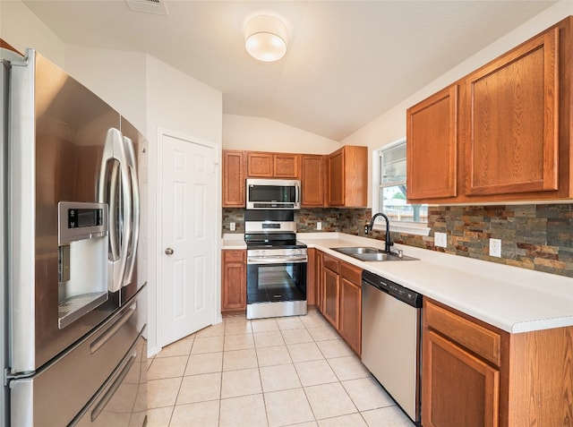 604 Creston St, Hutto, TX 78634 - kitchen with stainless steel appliances, a sink, vaulted ceiling, tasteful backsplash, and light countertops