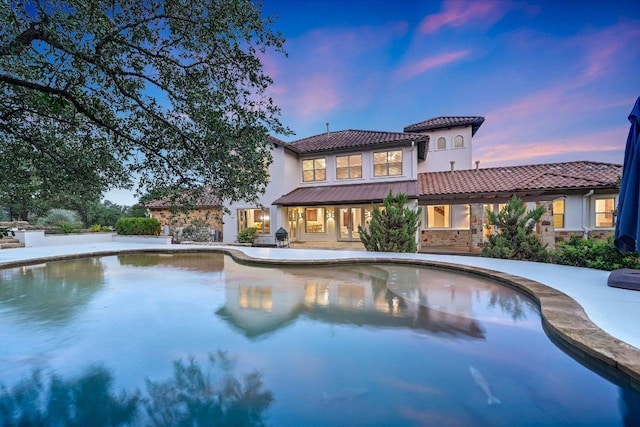 9308 Prince Charles, Austin, TX 78730 - rear view of property with an outdoor pool, a tiled roof, stone siding, stucco siding, and a patio area