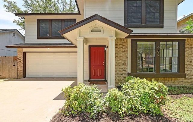 909 Silcantu Dr, Austin, TX 78748 - doorway to property featuring brick siding, concrete driveway, and an attached garage