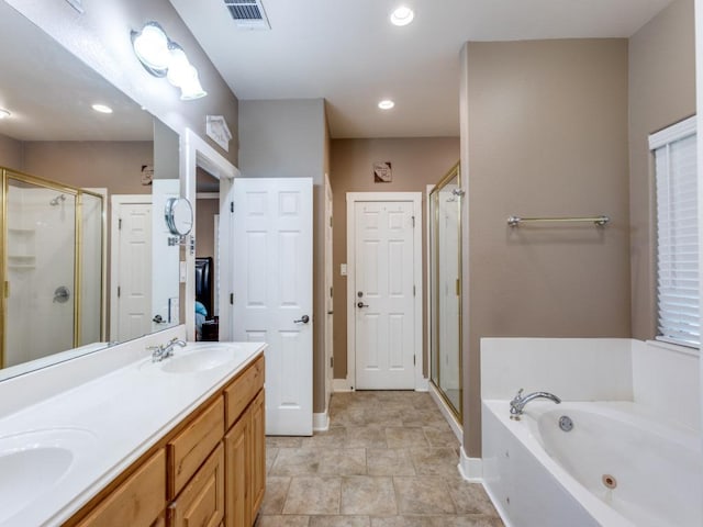 20104 Bunker Cv, Lago Vista, TX 78645 - bathroom featuring a shower stall, a tub with jets, double vanity, and recessed lighting