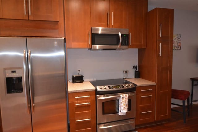 3404 American Dr Unit 2101, Lago Vista, TX 78645 - kitchen featuring stainless steel appliances, light countertops, brown cabinetry, and dark wood-style floors