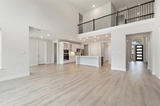 159 Fireside Rd, Austin, TX 78737 - unfurnished living room with a high ceiling, light wood finished floors, and recessed lighting