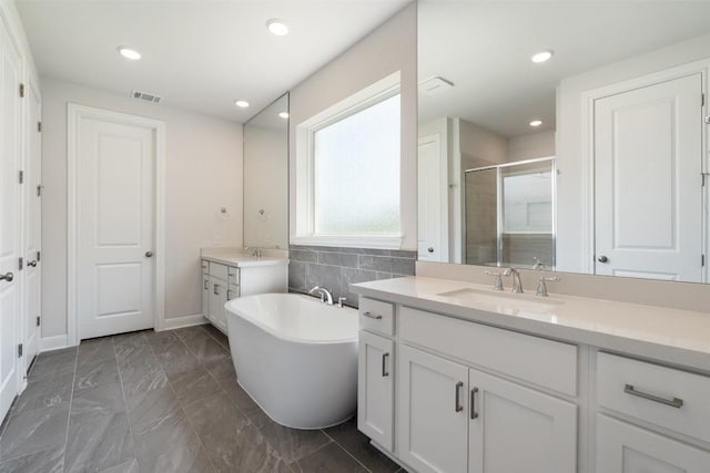 159 Fireside Rd, Austin, TX 78737 - bathroom with two vanities, a soaking tub, a shower stall, marble finish floors, and recessed lighting