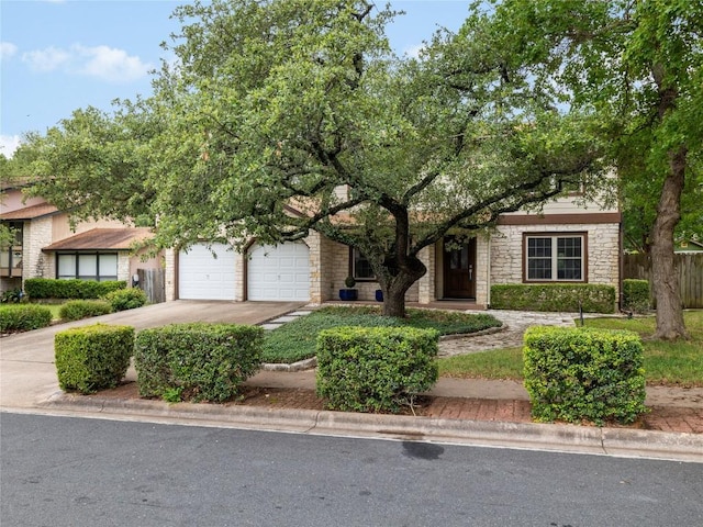 12208 Antoinette Pl, Austin, TX 78727 - obstructed view of property with stone siding, driveway, and a garage