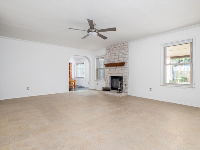 12208 Antoinette Pl, Austin, TX 78727 - unfurnished living room featuring ceiling fan, arched walkways, healthy amount of natural light, ornamental molding, and a stone fireplace
