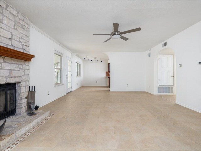12208 Antoinette Pl, Austin, TX 78727 - unfurnished living room with a ceiling fan, a fireplace, and arched walkways