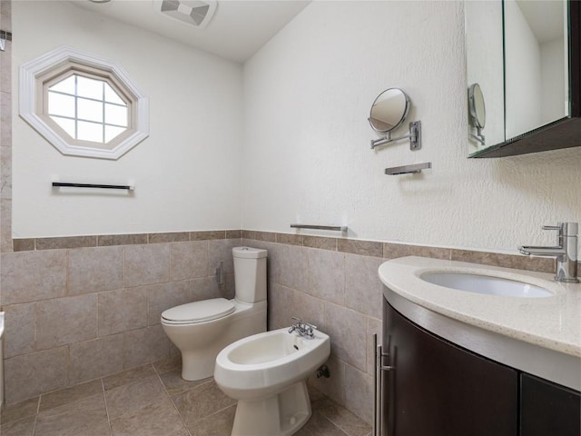 12208 Antoinette Pl, Austin, TX 78727 - bathroom with a bidet, vanity, wainscoting, and tile walls