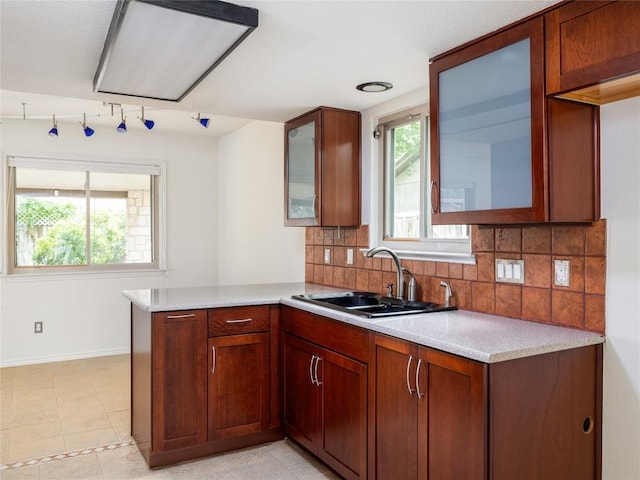12208 Antoinette Pl, Austin, TX 78727 - kitchen featuring a peninsula, glass insert cabinets, light countertops, and tasteful backsplash