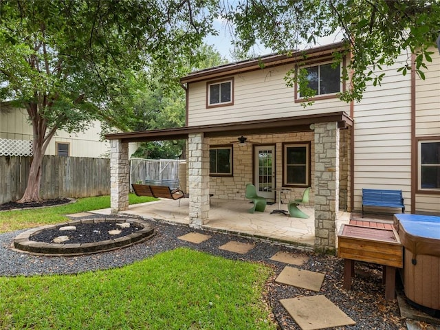 12208 Antoinette Pl, Austin, TX 78727 - rear view of house featuring a ceiling fan, a patio area, an outdoor fire pit, and stone siding