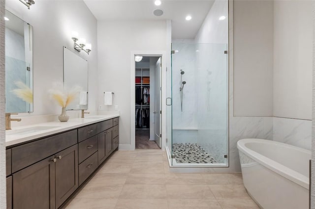 4702 Unity Cir, Austin, TX 78731 - bathroom with a stall shower, a freestanding tub, double vanity, a walk in closet, and recessed lighting