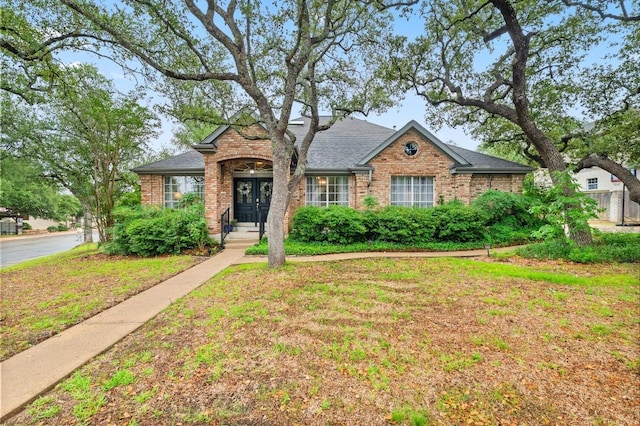8007 Weldon Springs Ct, Austin, TX 78726 - view of front of home with french doors, brick siding, a front lawn, and a shingled roof