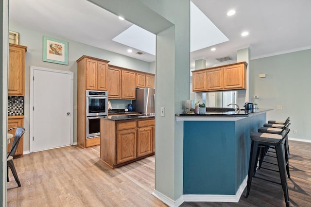 8007 Weldon Springs Ct, Austin, TX 78726 - kitchen featuring stainless steel appliances, light wood-style floors, dark countertops, crown molding, and recessed lighting