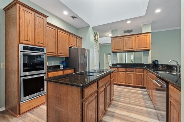 8007 Weldon Springs Ct, Austin, TX 78726 - kitchen featuring stainless steel appliances, light wood-type flooring, dark stone counters, a kitchen island, and recessed lighting