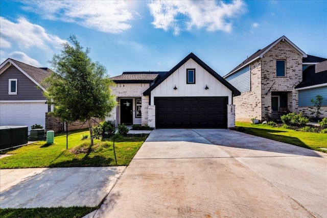 185 Standing Rock Ln, Marble Falls, TX 78654 - modern farmhouse style home with board and batten siding, a front yard, driveway, and brick siding
