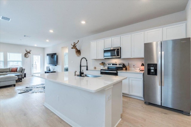 185 Standing Rock Ln, Marble Falls, TX 78654 - kitchen featuring appliances with stainless steel finishes, a sink, light wood-style flooring, white cabinets, and recessed lighting
