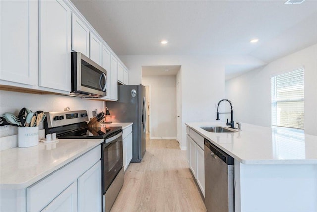 185 Standing Rock Ln, Marble Falls, TX 78654 - kitchen featuring stainless steel appliances, a sink, a center island with sink, light wood-style flooring, and white cabinets