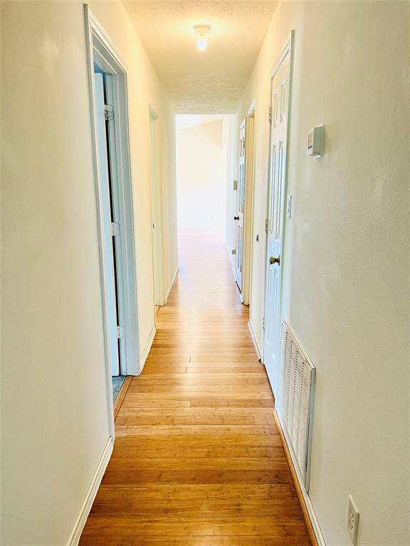 2105 W Gillis Ave, Cameron, TX 76520 - hall with light wood finished floors and baseboards