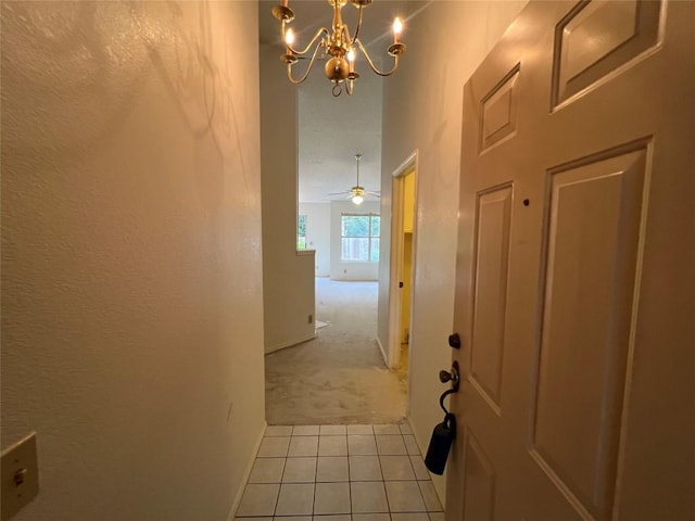6612 Zequiel Dr, Austin, TX 78744 - hallway with light colored carpet, a chandelier, light tile patterned floors, and baseboards