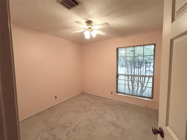6612 Zequiel Dr, Austin, TX 78744 - spare room with a ceiling fan, a textured ceiling, concrete floors, and baseboards