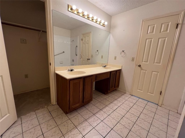 6612 Zequiel Dr, Austin, TX 78744 - full bath featuring double vanity, a textured ceiling, tile patterned flooring, and a walk in closet