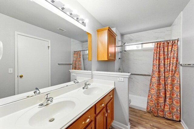 5000 Acorn Grove Ct, Austin, TX 78744 - bathroom with wood finished floors, double vanity, curtained shower, and toilet