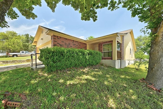 5000 Acorn Grove Ct, Austin, TX 78744 - view of property exterior with brick siding, an attached garage, and a yard