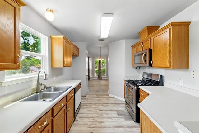 5000 Acorn Grove Ct, Austin, TX 78744 - kitchen featuring appliances with stainless steel finishes, a sink, light wood finished floors, and light countertops