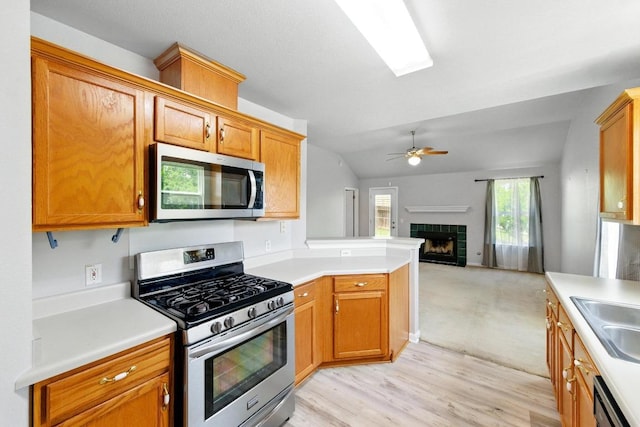 5000 Acorn Grove Ct, Austin, TX 78744 - kitchen featuring stainless steel appliances, open floor plan, ceiling fan, a fireplace, and light countertops