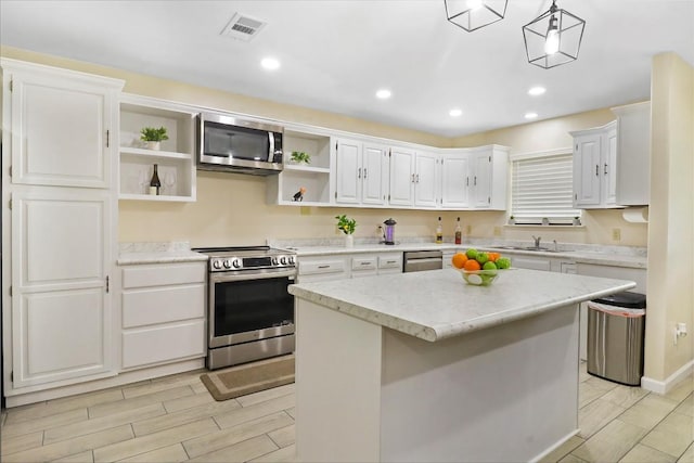 1313 Oakridge Dr, Blanco, TX 78606 - kitchen with appliances with stainless steel finishes, open shelves, white cabinets, recessed lighting, and a center island