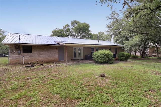 1313 Oakridge Dr, Blanco, TX 78606 - rear view of house with french doors, brick siding, and metal roof