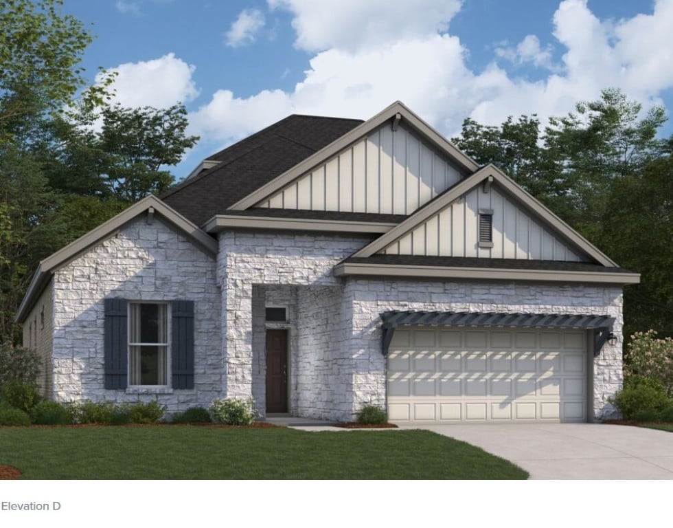 3713 Prosper Rd, Leander, TX 78641 - view of front of home with board and batten siding, stone siding, driveway, and a garage