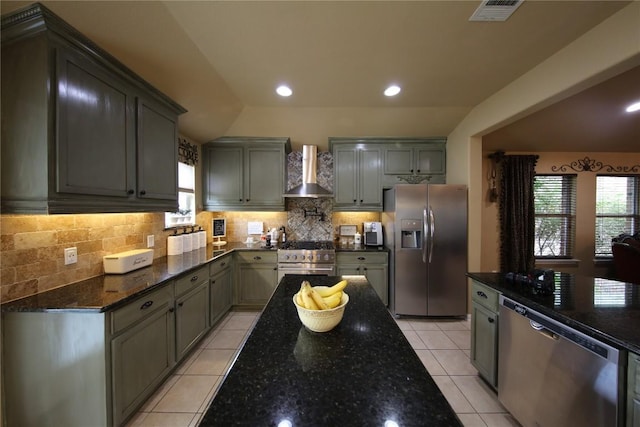 2721 Saddle Blanket Pl, Leander, TX 78641 - kitchen featuring appliances with stainless steel finishes, wall chimney range hood, dark stone counters, tasteful backsplash, and recessed lighting