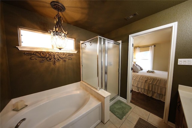 2721 Saddle Blanket Pl, Leander, TX 78641 - bathroom featuring a garden tub, a shower stall, tile patterned flooring, a chandelier, and a textured wall