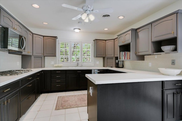 2509 Spring Ln, Austin, TX 78703 - kitchen featuring stainless steel appliances, a sink, backsplash, a ceiling fan, and recessed lighting
