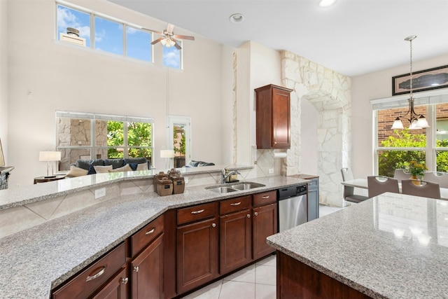 21105 Huckabee Bnd, Pflugerville, TX 78660 - kitchen with stainless steel dishwasher, a sink, light stone counters, ceiling fan, and plenty of natural light
