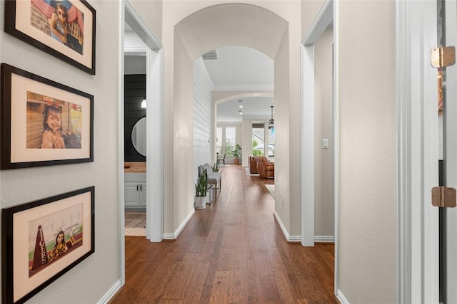 562 Stone River Dr, Austin, TX 78737 - corridor with arched walkways, dark wood finished floors, baseboards, and crown molding