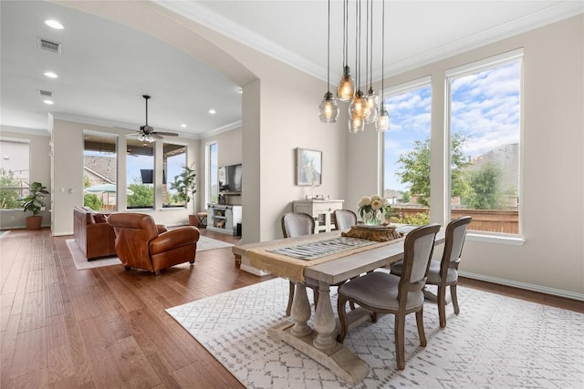 562 Stone River Dr, Austin, TX 78737 - dining space featuring arched walkways, crown molding, wood finished floors, ceiling fan, and baseboards