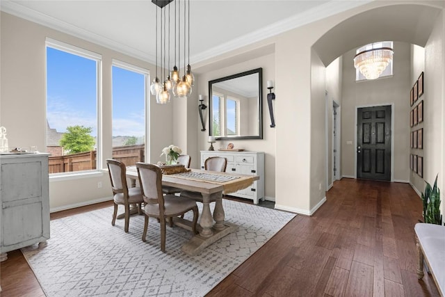 562 Stone River Dr, Austin, TX 78737 - dining space with a chandelier, arched walkways, dark wood-style floors, baseboards, and crown molding