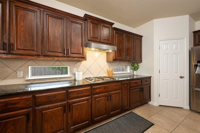 112 Bearing Cv, Austin, TX 78717 - kitchen with under cabinet range hood, stainless steel appliances, dark stone countertops, and decorative backsplash