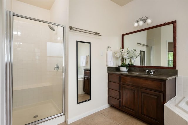 112 Bearing Cv, Austin, TX 78717 - bathroom with a stall shower, tile patterned flooring, vanity, a garden tub, and baseboards
