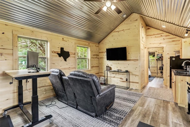 11700 Rim Rock Trl, Austin, TX 78737 - living room featuring wooden walls, lofted ceiling, a ceiling fan, plenty of natural light, and light wood-style flooring