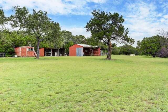 11700 Rim Rock Trl, Austin, TX 78737 - view of grassy yard featuring an outdoor structure, an outbuilding, and view of scattered trees
