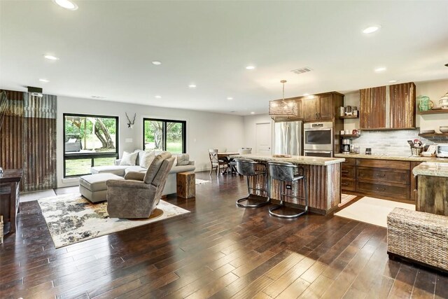 11700 Rim Rock Trl, Austin, TX 78737 - kitchen featuring appliances with stainless steel finishes, open shelves, a center island, a kitchen breakfast bar, and pendant lighting